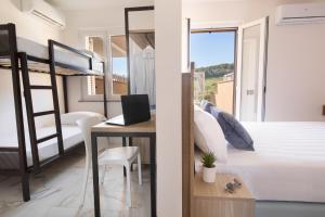 een slaapkamer met een bed en een bureau met een laptop bij Pietra Bianca Residence in Numana