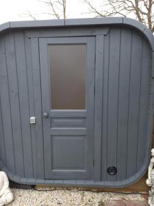 a gray garage with a door on the side at bungalow Onder de iep in Ermelo