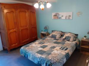 1 dormitorio con 1 cama y armario de madera en Chambres d'hôtes Chez Barbara, en Tardets-Sorholus