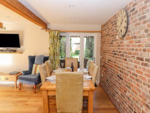 une salle à manger avec une table et un mur en briques dans l'établissement The Pine, à Skegness