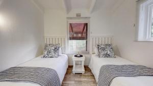 zwei Einzelbetten in einem Zimmer mit Fenster in der Unterkunft San Lameer Villa 3002 by Top Destinations Rentals in Southbroom