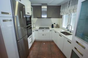 a kitchen with white cabinets and a stainless steel refrigerator at Piso Angueira in Cee