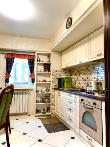 Una cocina con gabinetes blancos y un horno de estufa. en Apartament Ultraconfort, en Iaşi