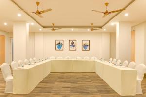 a large room with a long table and white chairs at Keys Lite by Lemon Tree Hotels, Tapovan, Rishikesh in Rishīkesh