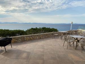a patio with tables and chairs overlooking the water at Hotel Club Sunway Punta Prima in Es Pujols