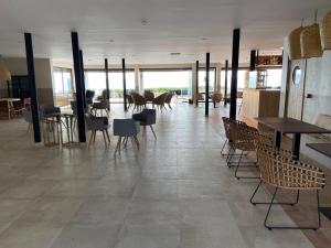 a large room with tables and chairs in a building at Hotel Club Sunway Punta Prima in Es Pujols