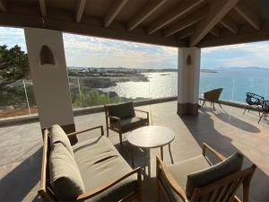 a patio with chairs and a table and a view of the water at Hotel Club Sunway Punta Prima in Es Pujols