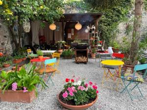 un patio con mesas coloridas, sillas y flores en Villa Clelia, en Levanto