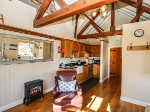 a kitchen with wooden cabinets and a chair in a room at The Dairy in Skegness