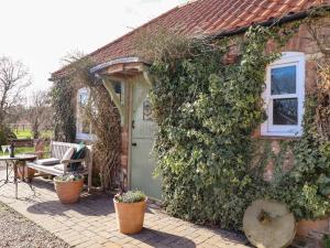 a brick house with a green door and ivy at The Dairy in Skegness