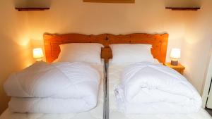 1 dormitorio con 2 camas y almohadas blancas en Au coeur du Parc National de la Vanoise Appart Termignon Val Cenis, en Termignon