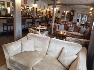 a living room with couches and tables and a bar at The Harbour Moon in Looe