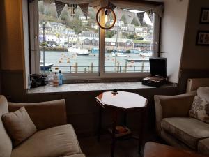 a living room with a large window with a view of a harbor at The Harbour Moon in Looe