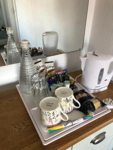 a tray with cups and other items on a counter at The Fossil Tree Hotel in Blackpool