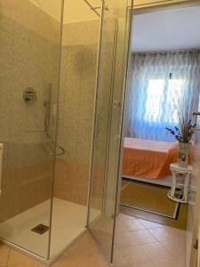 a shower with a glass door in a room with a bed at AL PORTO DI SANTA in Santa Margherita Ligure