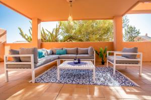 eine Veranda mit einem Sofa und Stühlen auf einer Terrasse in der Unterkunft Ample Luxury Apart Fancy Marbella Golf & Padel in Marbella + 68 Fotos