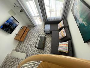 eine Draufsicht auf ein Wohnzimmer mit einem Sofa und einem Fernseher in der Unterkunft El Cortijo Bungalow - Pool - Free Parking in Playa de las Americas