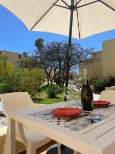 ein Tisch mit einem Weinglas und einem Sonnenschirm in der Unterkunft El Cortijo Bungalow - Pool - Free Parking in Playa de las Americas