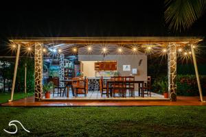 um gazebo com mesa, cadeiras e luzes em Tranquilidad Resort em Parrita