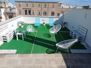 un patio con sedie e un prato verde in un edificio di B&B VOLARE a Polignano a Mare