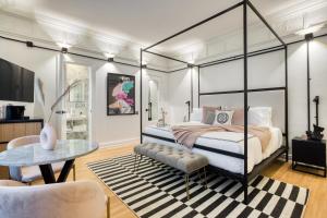 a bedroom with a canopy bed and a table at UTOPIC Campos Elíseos by ULIV in Mexico City