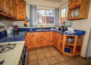 cocina con armarios de madera y encimera azul en Life of Riley-1608 by Big Bear Vacations, en Big Bear Lake