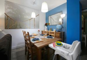 comedor con paredes azules y mesa y sillas de madera en Apartamento Las Rozas Village, en Las Rozas de Madrid