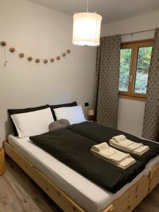 a bedroom with a large bed with a black blanket at Appartamenti e B&B Casa Ester in Baselga di Pinè