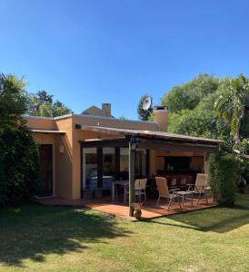 a house with a deck and chairs on it at Bungalow in Our Garden in Montevideo