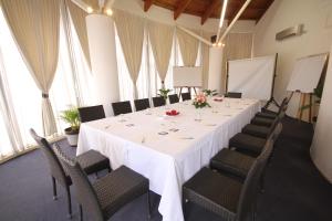 une salle de conférence avec une table et des chaises blanches dans l'établissement The Melanesian Port Vila, à Port Vila