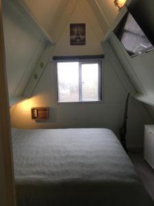 a attic bedroom with a bed and a window at Durbuy chalet 65 in Durbuy +21 photos