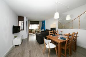 comedor y sala de estar con mesa y sillas en Apartamento Las Rozas Village, en Las Rozas de Madrid
