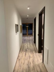 korytarz z białymi ścianami i drewnianą podłogą w obiekcie Appartamenti e B&B Casa Ester w mieście Baselga di Pinè