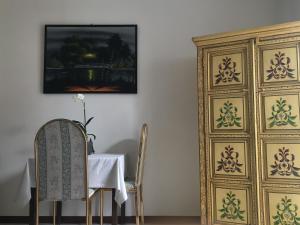 un comedor con una mesa y una pintura en la pared en La Rivetta, en Omegna