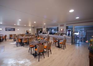 restauracja ze stołami i krzesłami oraz bar w obiekcie Hotel les Alignements w mieście Carnac