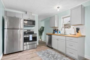a kitchen with white cabinets and a stainless steel refrigerator at Coral Cottage Unit 2 in Rockaway Beach