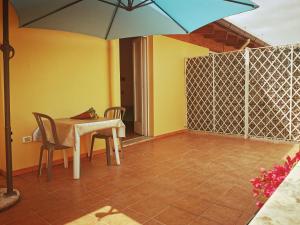 a patio with a table and chairs and an umbrella at Olympo in Bisceglie