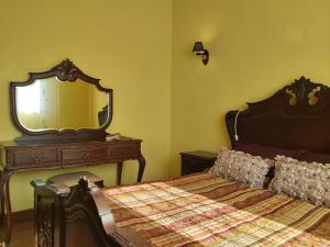 a bedroom with a bed with a dresser and a mirror at R3 Service - Cozy Old House in Borralha