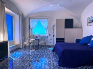 een hotelkamer met een bed en een tafel en stoelen bij Regina di Capri - Suite vista Faraglioni in Capri