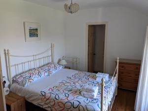ein Schlafzimmer mit einem Bett und einer Kommode in der Unterkunft Traditional Fisherman's Cottage with 3 bedrooms in Mousehole