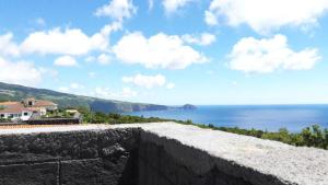 a stone wall with a view of the ocean at Casa da Pedra in Horta