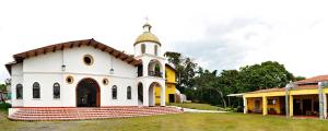 Eine weiße Kirche mit einem Kirchturm darüber. in der Unterkunft San Agustin Internacional Hotel in San Agustín