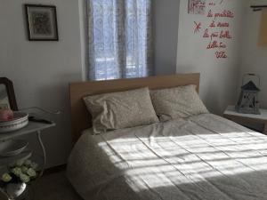 a bedroom with a bed with a white comforter and a window at CASA IL GLICINE in Rocchetta Palafea