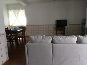 ein Wohnzimmer mit einem weißen Sofa und einem Tisch in der Unterkunft Maré Baixa in Sines