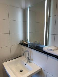 a bathroom with a sink and a large mirror at Georg Rass Gästehaus in Norderney