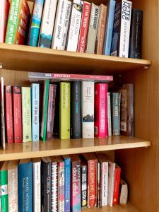 a book shelf filled with lots of books at Kamerlingh Villa in Oranjestad