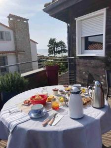 una mesa con un mantel blanco con comida. en LA CABANE DE L'ESTUAIRE chambres d'hôte, en Meschers-sur-Gironde