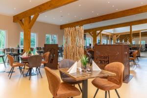 jadalnia ze stołami i krzesłami w restauracji w obiekcie Safariland Stukenbrock Erlebnisresort w mieście Schloß Holte-Stukenbrock