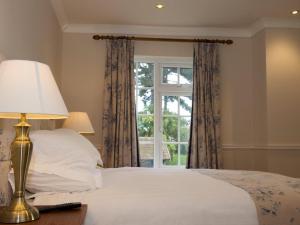 a bedroom with a bed with a lamp and a window at The Wellington Heifer in Northallerton