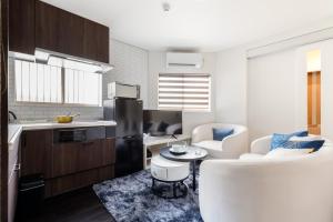 uma cozinha com uma mesa e algumas cadeiras num quarto em Hotel kiki em Osaka